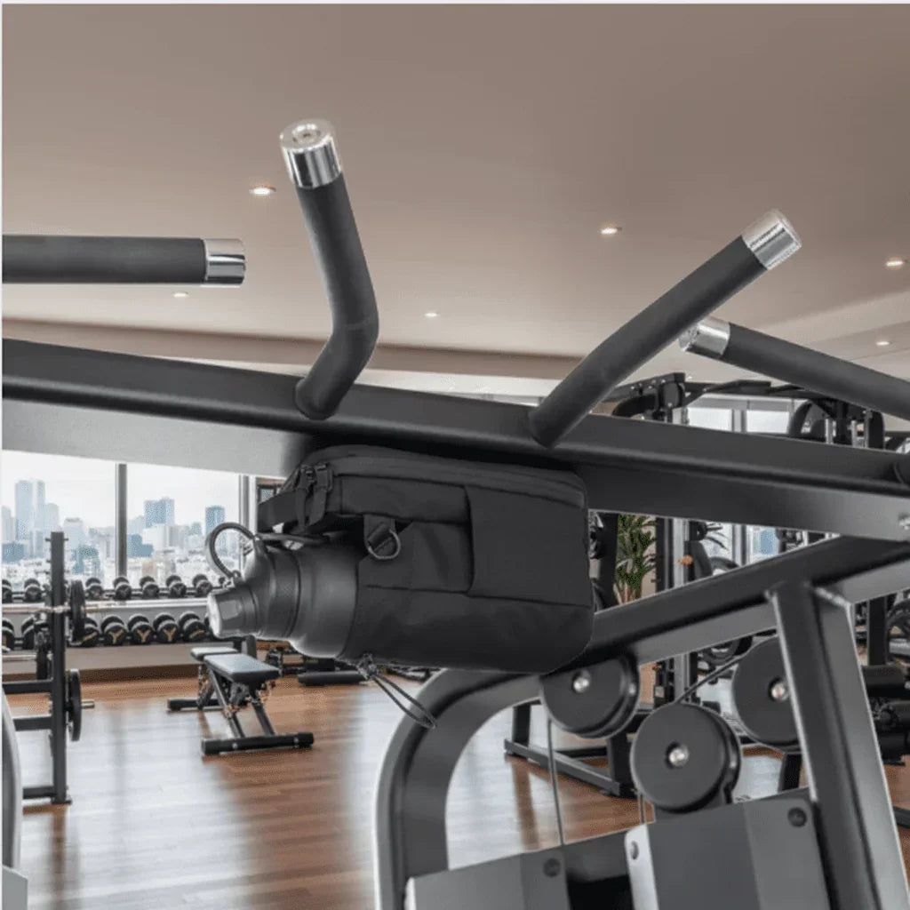 Magnetic gym bag holding a water bottle attached to gym equipment in a modern fitness center