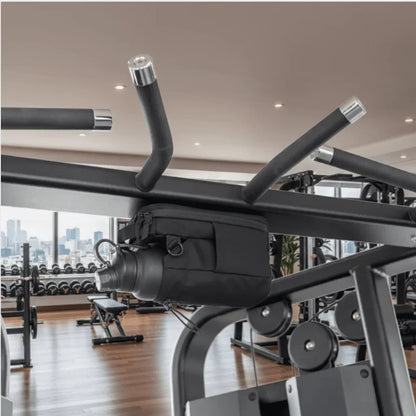 Magnetic gym bag holding a water bottle attached to gym equipment in a modern fitness center